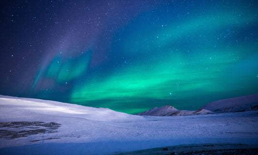 Majestätische Nordlichter tanzen über der schneebedeckten Arktis, eingefangen in leuchtenden Grüntönen. Perfekt als Leinwandbild oder Poster, um die Magie der Natur in Ihr Zuhause zu holen.